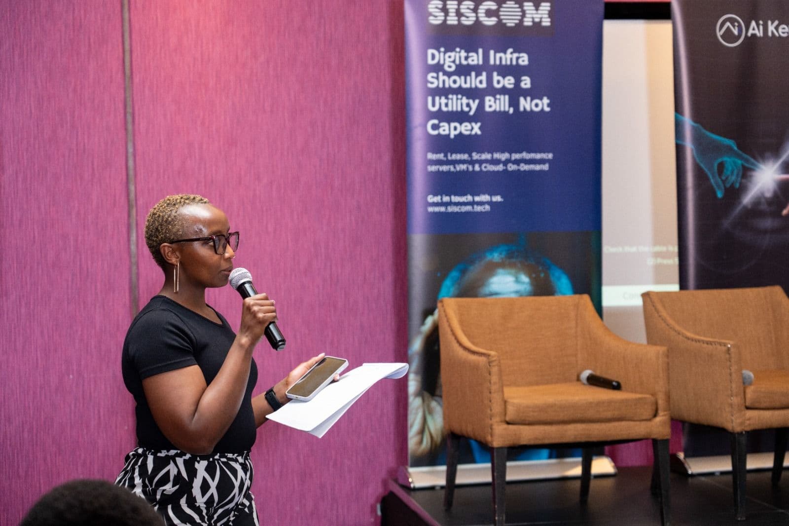 Speaker on stage with Siscom branding
